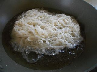 茹でた素麺を油で揚げる